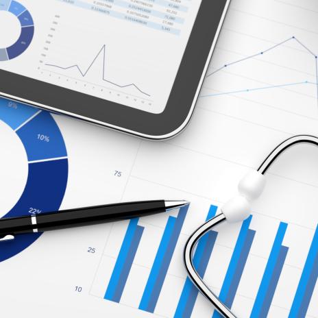 Stethoskop, Brille und Stift liegen über verschiedenen Auswertungen